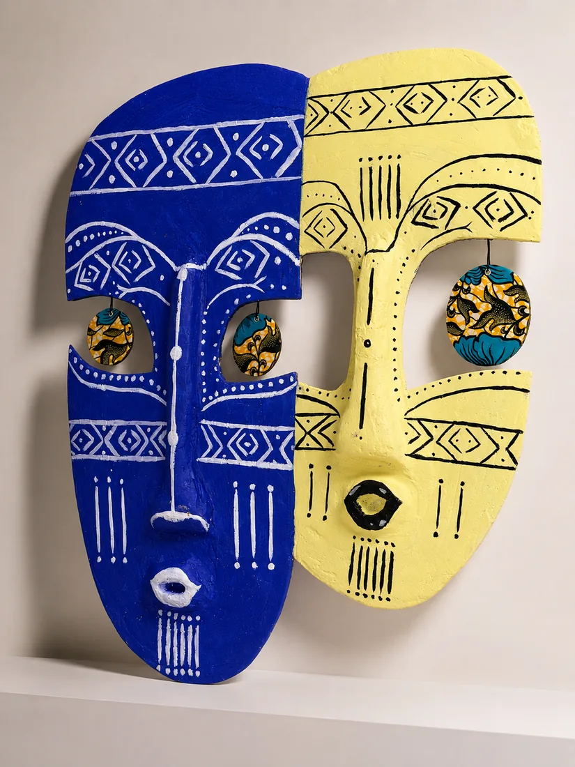 Deux visages côte à côte, l'un bleu outremer, l'autre jaune solaire, avec des disques de wax au niveau des yeux.
